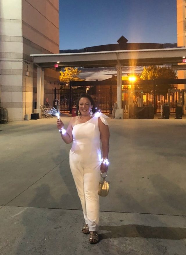 Alison Gary of Wardrobe Oxygen in a white one-shouldered jumpsuit at Diner en Blanc Washington DC 2018 at Nationals Park