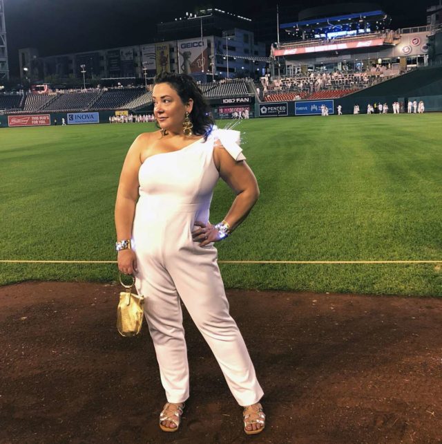 Alison Gary of Wardrobe Oxygen in a white one-shouldered jumpsuit at Diner en Blanc Washington DC 2018 at Nationals Park