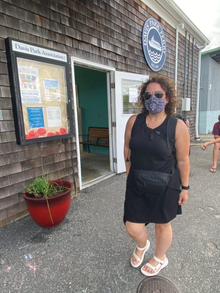Alison Gary of Wardrobe Oxygen at the ferry for Davis Park Fire Island wearing a black knit sundress and white Teva sandals