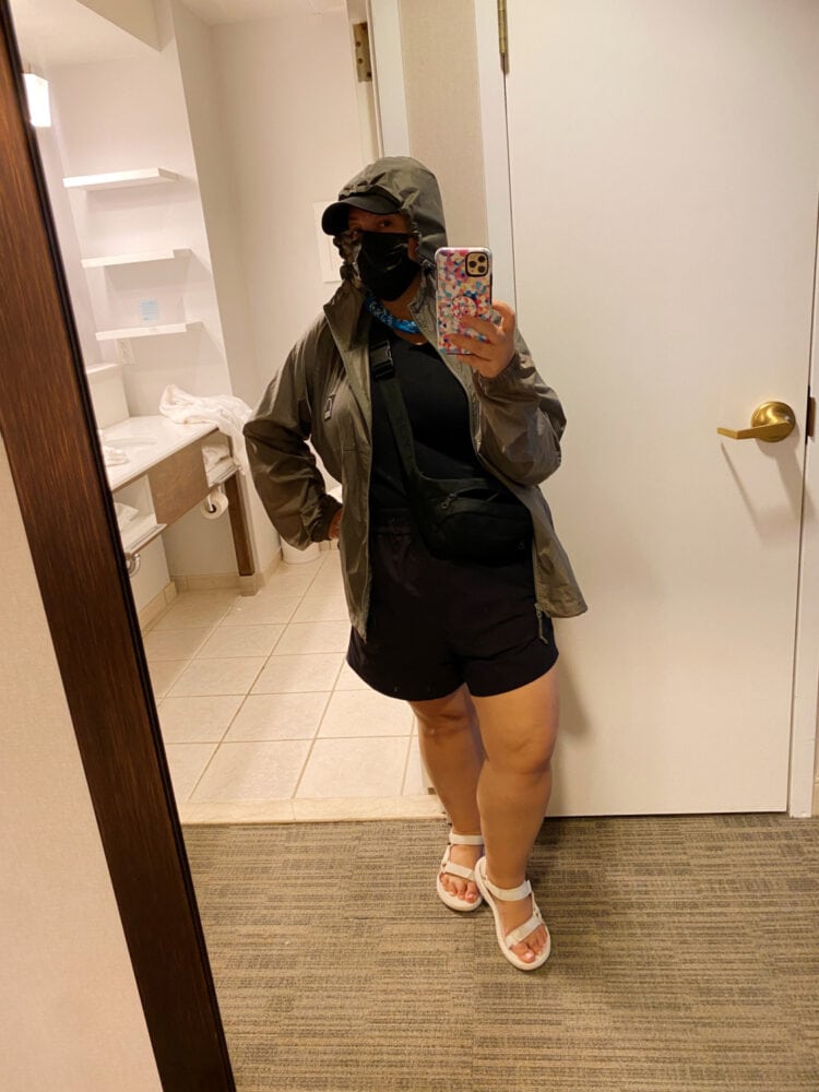 Alison Gary of Wardrobe Oxygen taking a selfie in a hotel room, wearing a raincoat