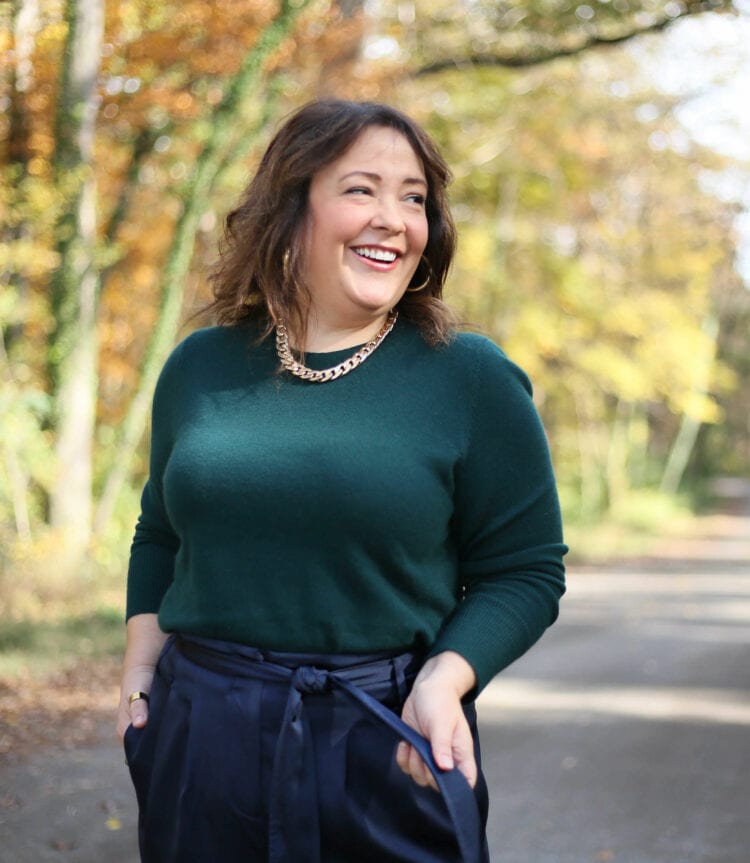 Alison in the green sweater smiling away from the camera