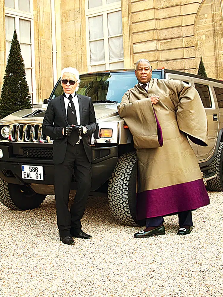 Karl Lagerfeld and Andre Leon Talley standing in front of a Hummer