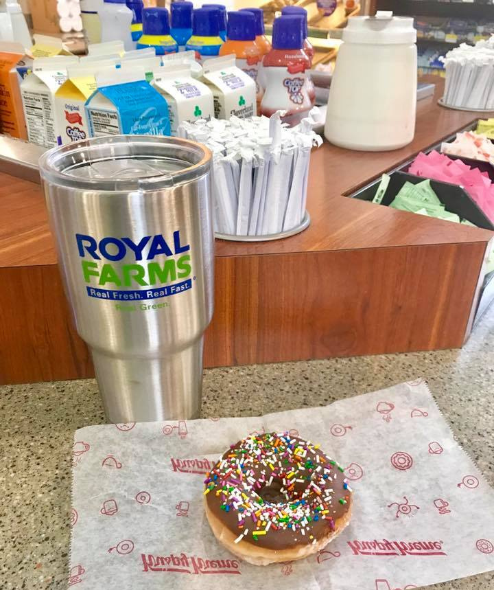 A Royal Farms stainless tumbler and a chocolate sprinkle donut