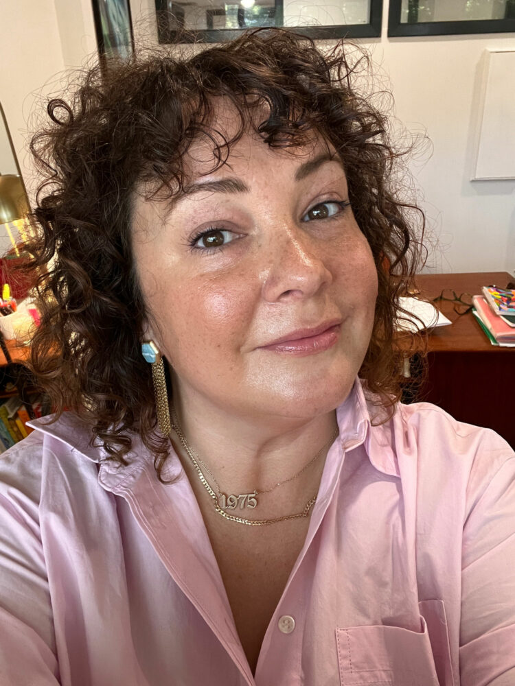 Alison Gary of Wardrobe Oxygen wearing Marcia Moran earrings with a gold Gorjana link necklace and a gold pendant necklace with the numbers 1975