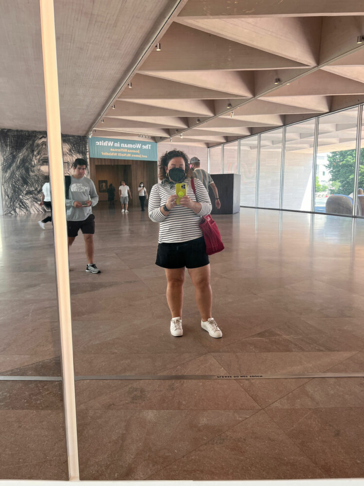 Alison Gary of Wardrobe Oxygen in a Breton striped top and black shorts taking a mirror selfie at the National Gallery of Art in Washington, D.C>