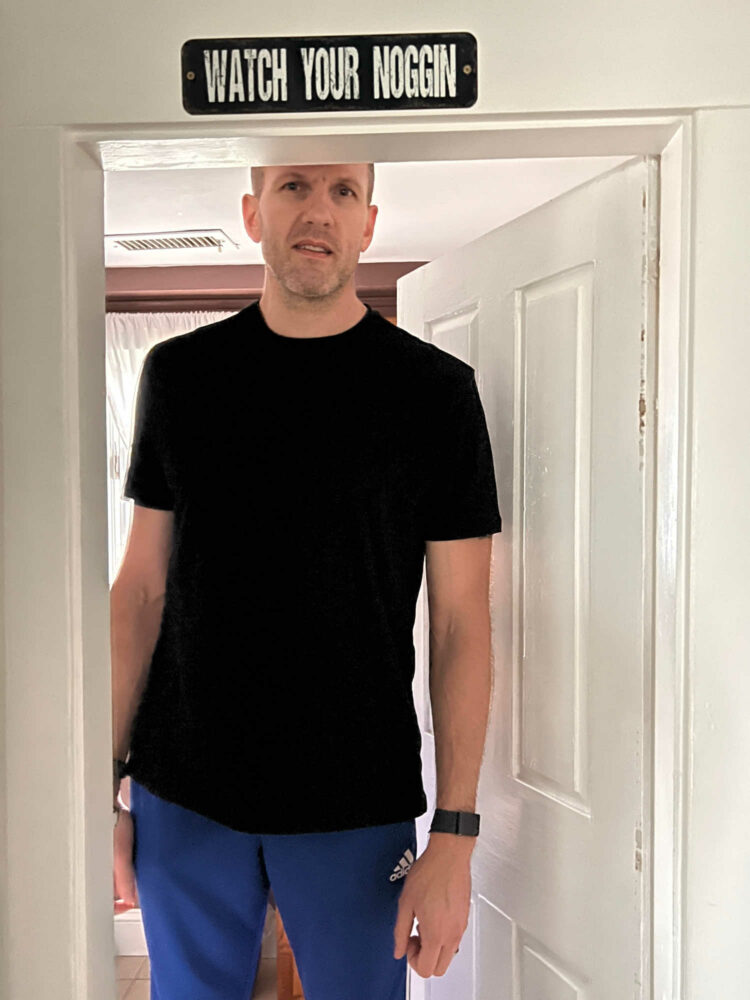 man in a black Banana Republic t-shirt and blue Adidas track pants