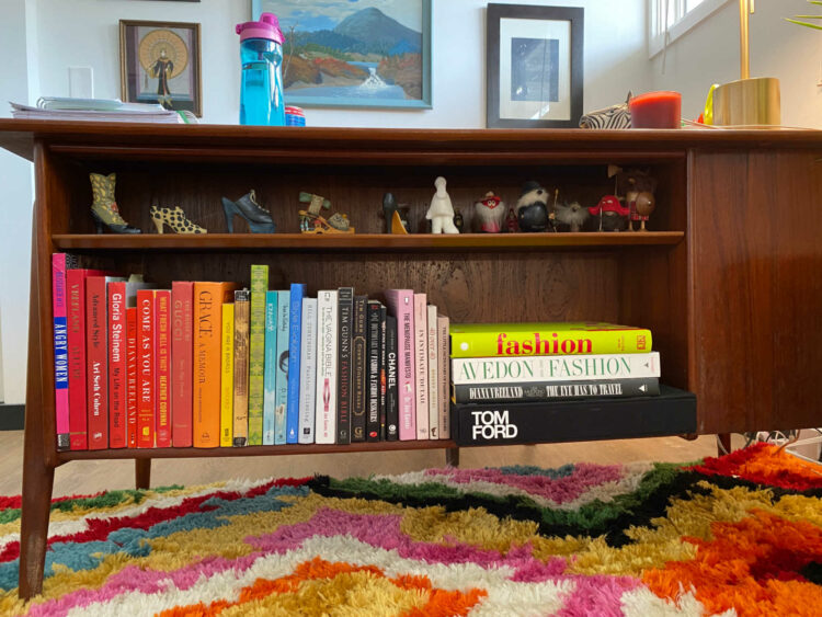 coloful books on the shelf of a mid century modern desk
