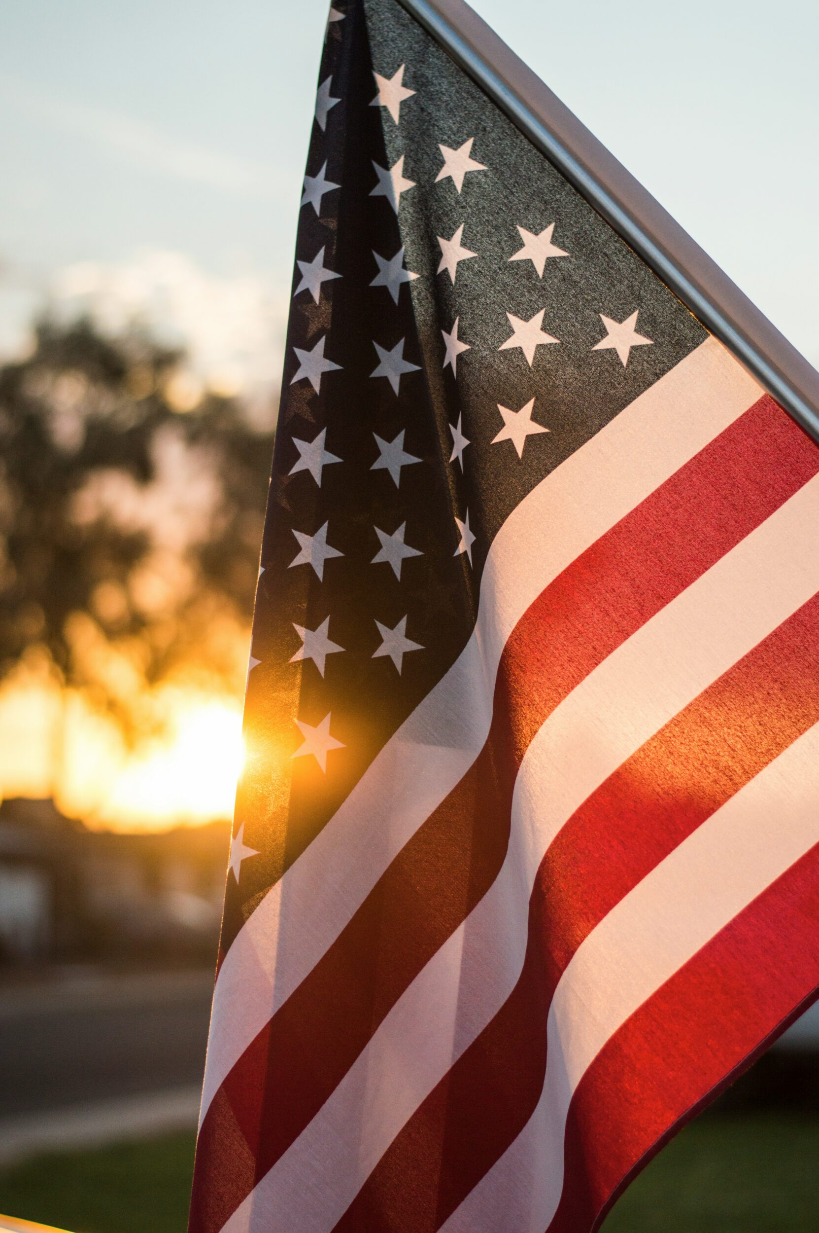 an american flag flying at sunset