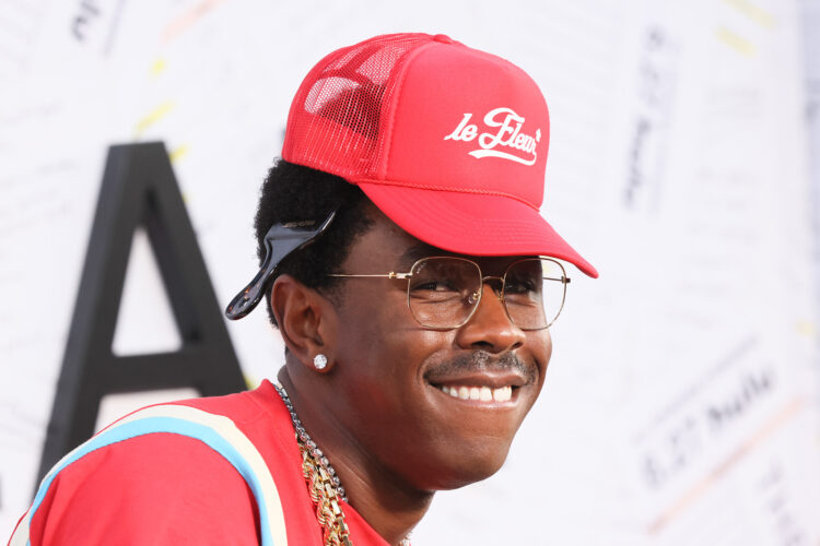 Tyler, the Creator in a red trucker cap and gold metal glasses