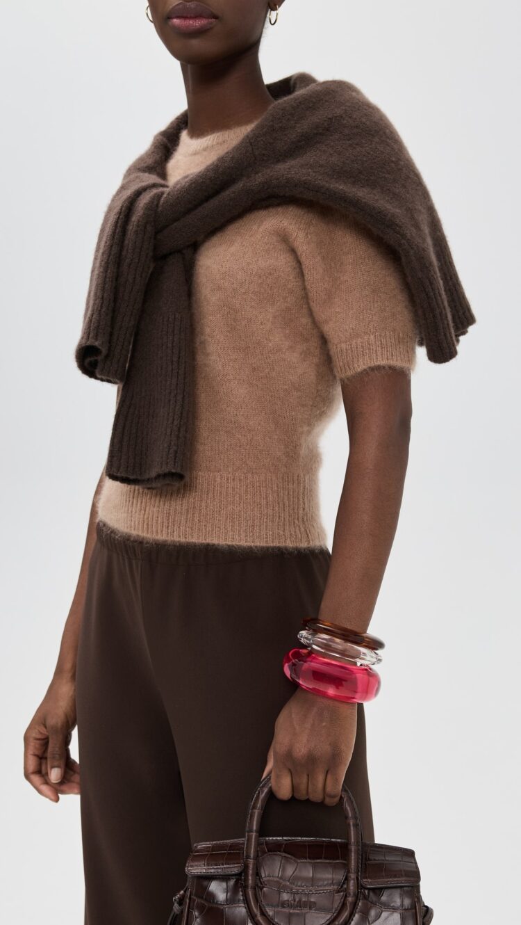 Why I'm Embracing the Bangle Bracelet Trend 6 a model wearing three bangles in pink, clear, and brown