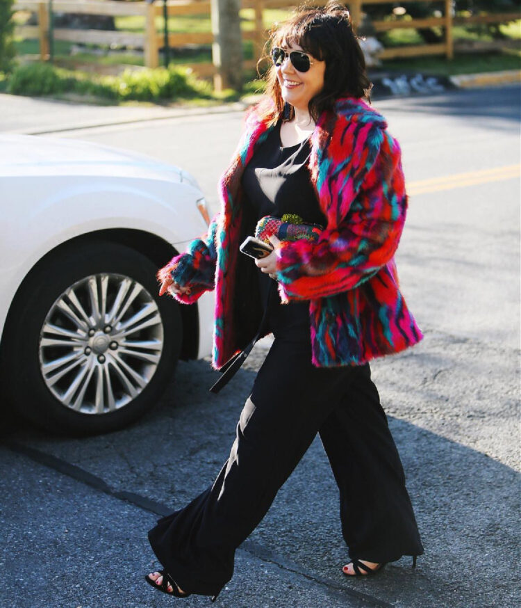 What I Wore to an Embassy Gala 9 Alison Gary of Wardrobe Oxygen in 2018 wearing a black jumpsuit and a rainbow colored faux fur coat from ASOS